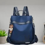 Stylish navy blue women’s backpack purse displayed on modern table setup indoors