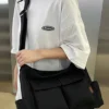 Large black canvas messenger shoulder bag with multiple pockets and adjustable strap