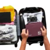 Travel tech organizer pouch placed inside suitcase with gadgets and accessories