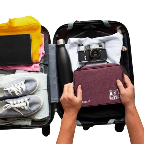 Travel tech organizer pouch placed inside suitcase with gadgets and accessories