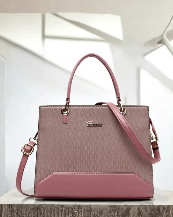 Premium pink structured handbag for women with textured finish, detachable shoulder strap, dual handles, and elegant gold-tone details.