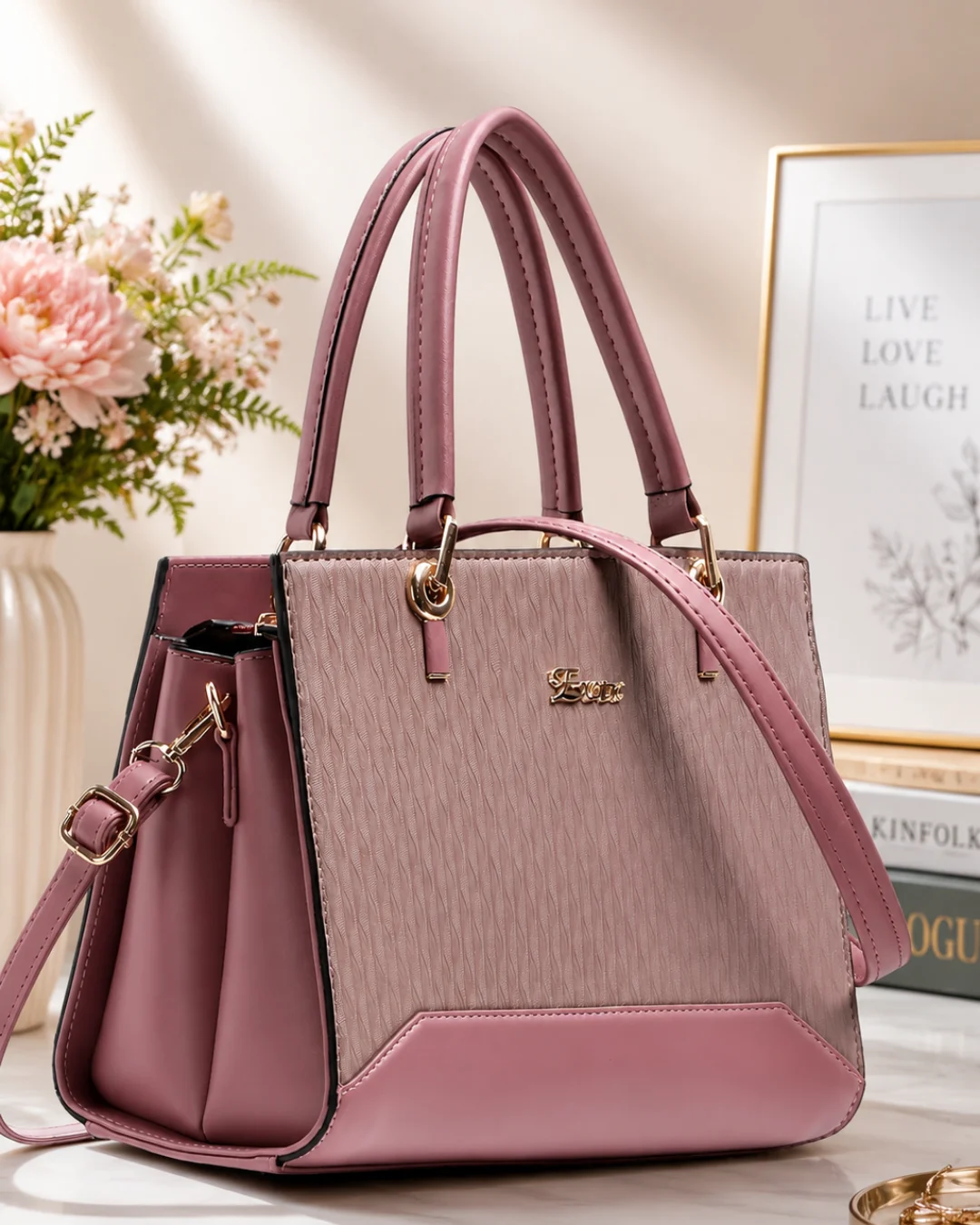 Premium pink structured handbag for women with dual handles, detachable shoulder strap, textured finish, and spacious compartments for daily use.